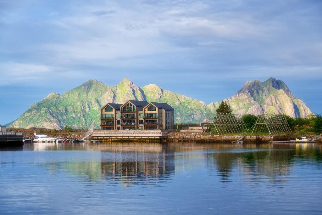 Moderne Gebäude neben klassischen Trockengestellen, Svolvaer, Lofoten, Norwegen